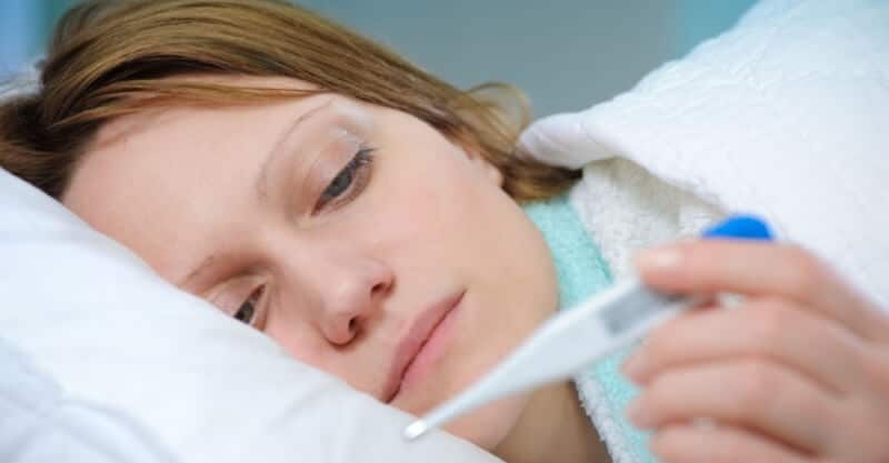 Mulher a medir a temperatura por causa da febre alta