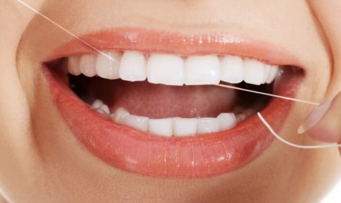 Fio dentário na boca