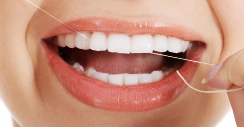 Fio dentário na boca