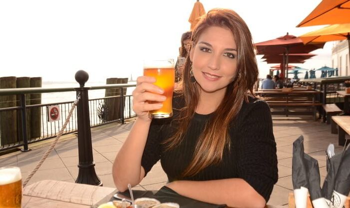 Mulher a exibir uma caneca de cerveja