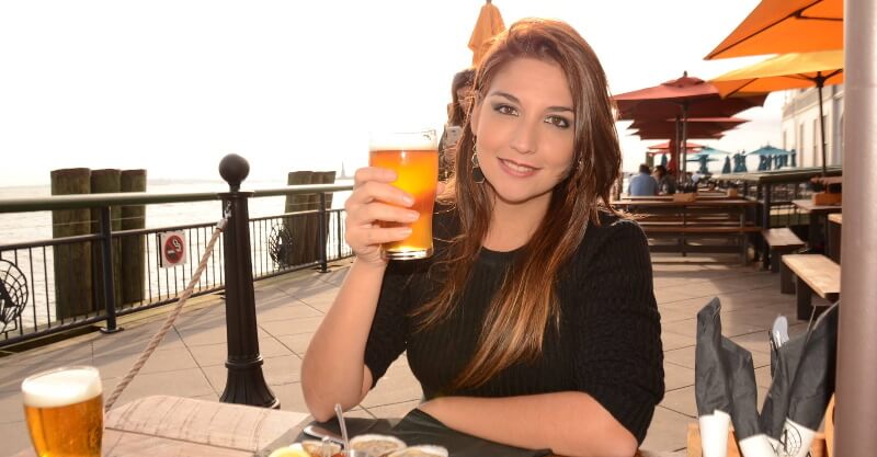 Mulher a exibir uma caneca de cerveja