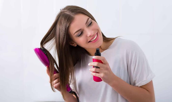Mulher a aplicar shampô seco no cabelo