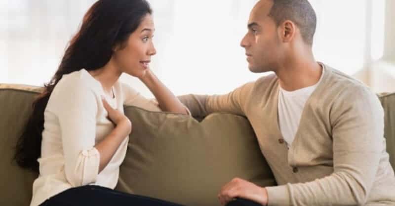 Casal ao sofá a debaterem um assunto