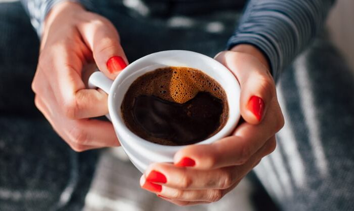 Mulher com um copo de café descafeinado