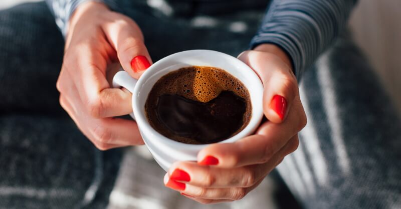 Mulher com um copo de café descafeinado