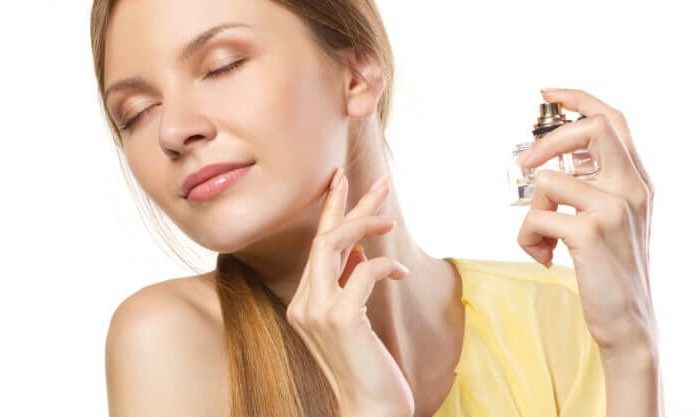 Mulher borrifando com perfumes