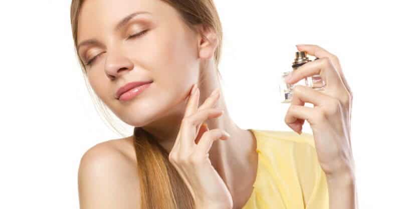 Mulher borrifando com perfumes