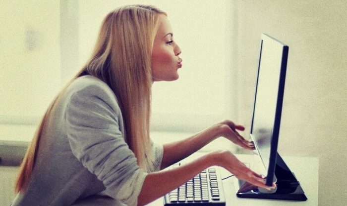 Mulher comunica com companheiro/a através do computador