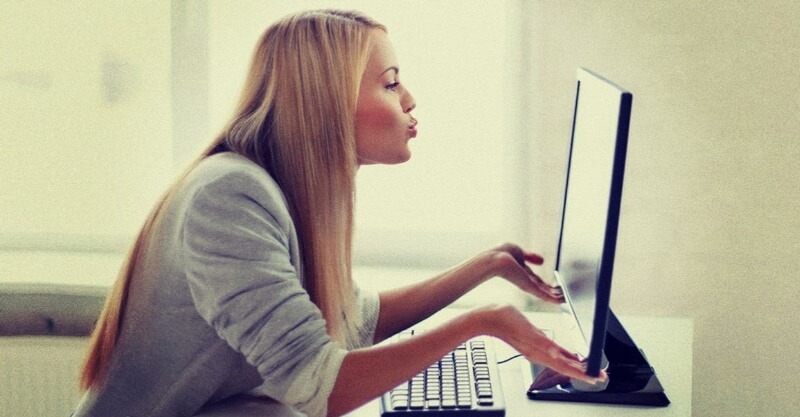 Mulher comunica com companheiro/a através do computador